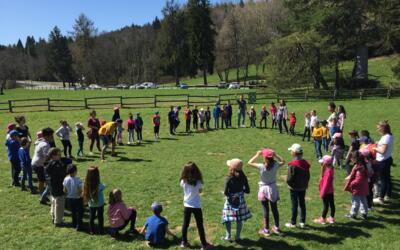 Groupe d'enfants jouant sur l'herbe dans le parc du centre Les Puisots UFOVAL à Annecy