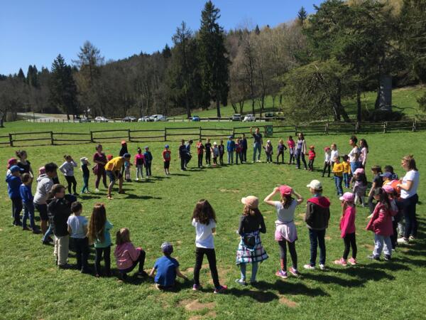 Groupe d'enfants jouant sur l'herbe dans le parc du centre Les Puisots UFOVAL à Annecy